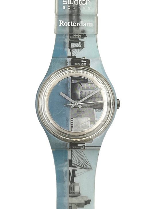 Swatch Access Rotterdam wristwatch with a translucent light blue strap featuring a black and white cityscape print, and a silver-toned circular case.