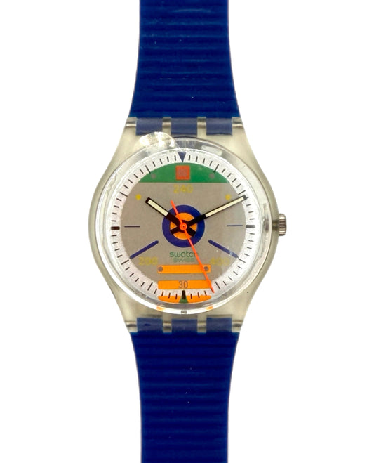 A Swizzlin' Swatches wristwatch featuring a bright blue textured silicone strap, a silver-tone case, and a colorful dial with a blue circular logo and orange accents.