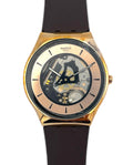 Swatch watch with black strap and gold case on a white background
