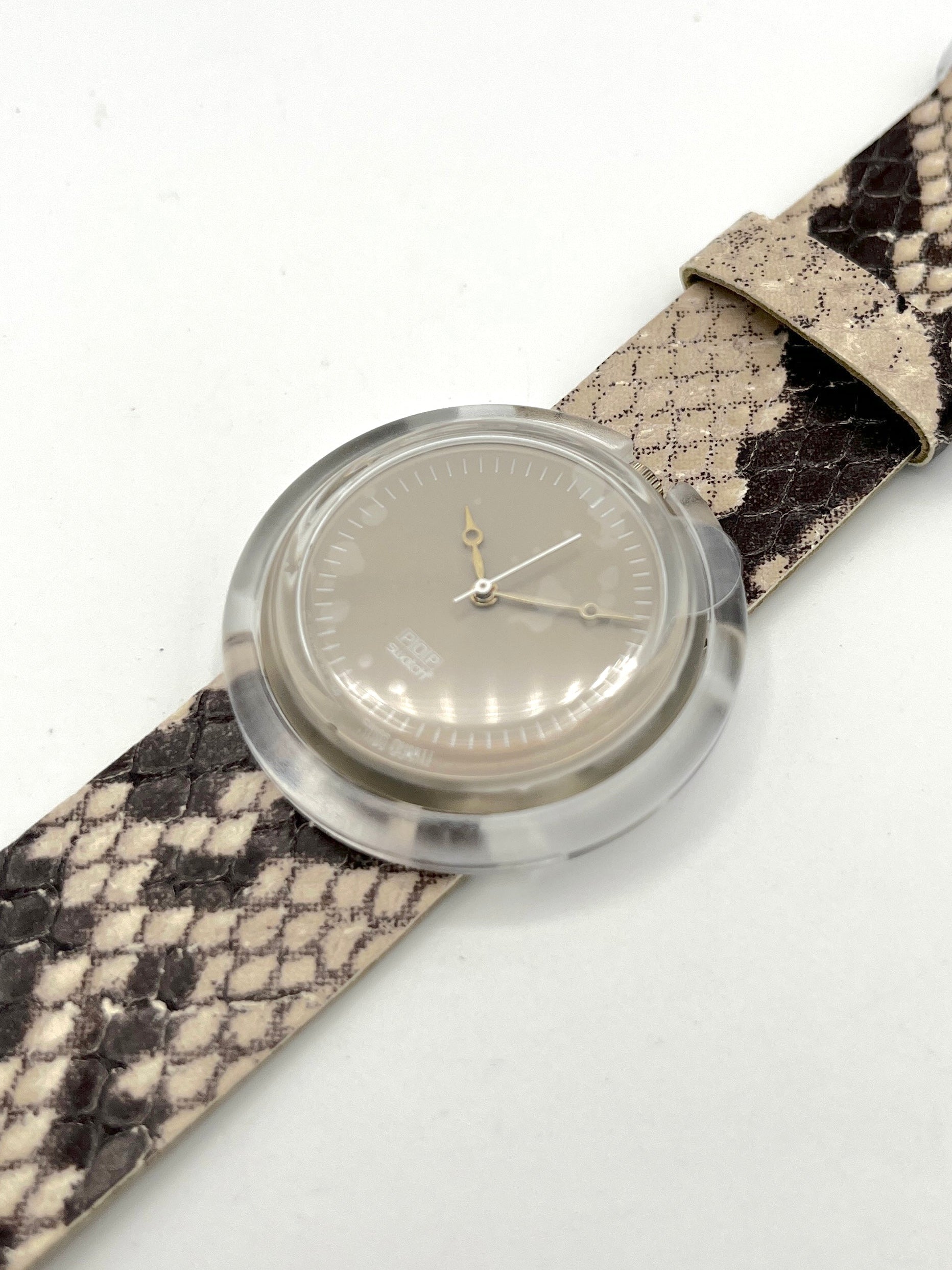Watch with a snake skin strap on a white background
