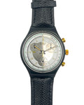 A vintage-style wristwatch with a textured black strap, a dark gunmetal bezel, and a silver dial featuring a heart-shaped cutout design and gold-tone accents.