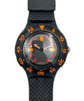 A Swatch wristwatch with a black textured strap, black bezel, and a black dial featuring bright orange and red accents.
