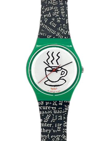 A Swatch wristwatch featuring a green case, a white dial with a black coffee cup illustration, and a black and white patterned strap.
