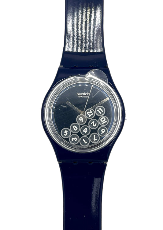 Navy blue Swatch watch with a clear face showing numbers on a white background